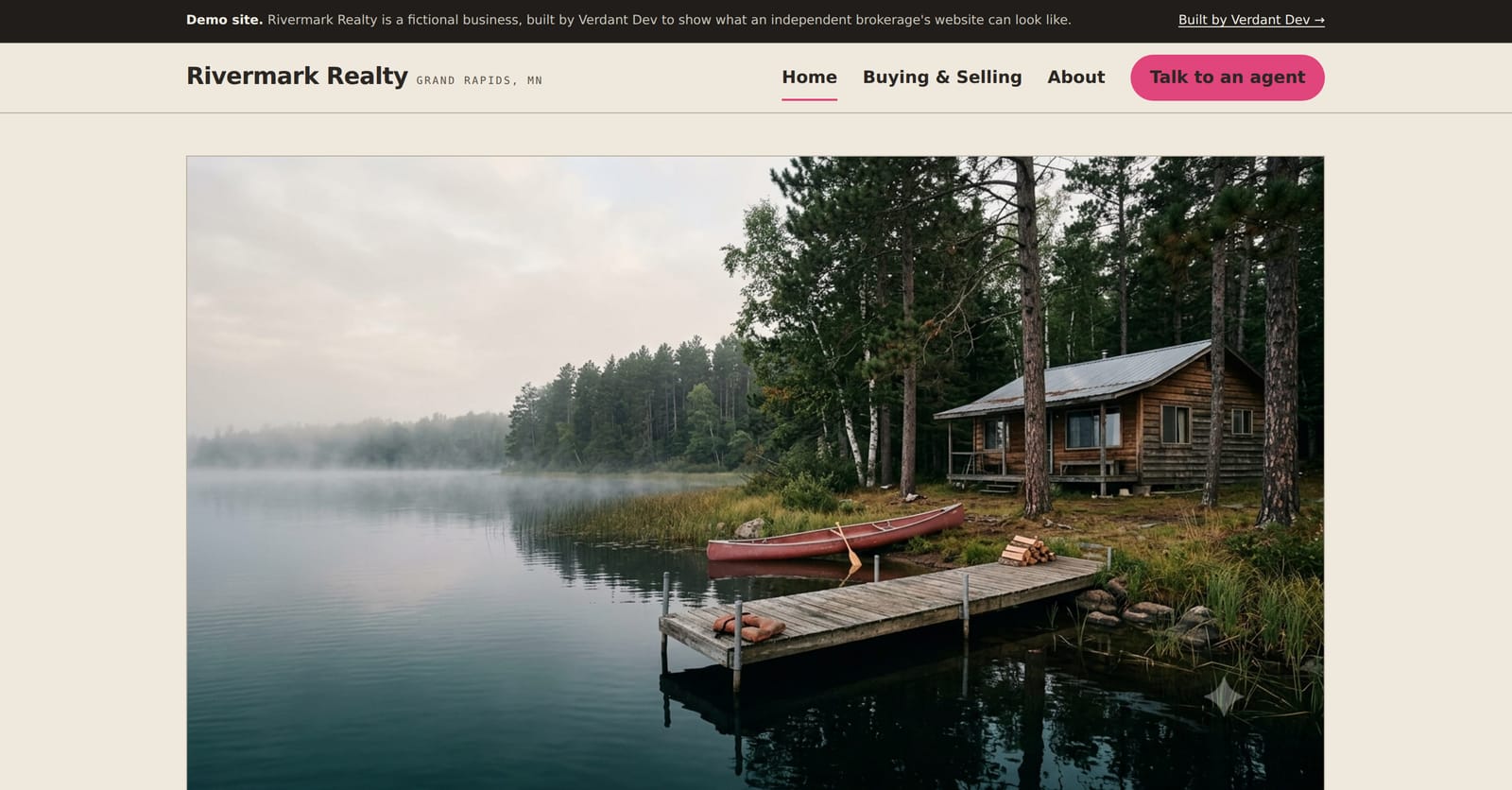The Rivermark Realty example site — a foggy northern-Minnesota lake and cabin at dawn above a 'Homes, lakefront, and land around Grand Rapids' headline.